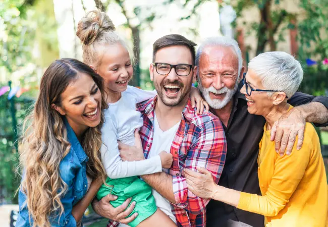 Multi-generational family laughing outdoors together